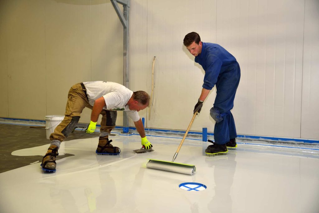 Waterproof protective coating being applied to a commercial floor